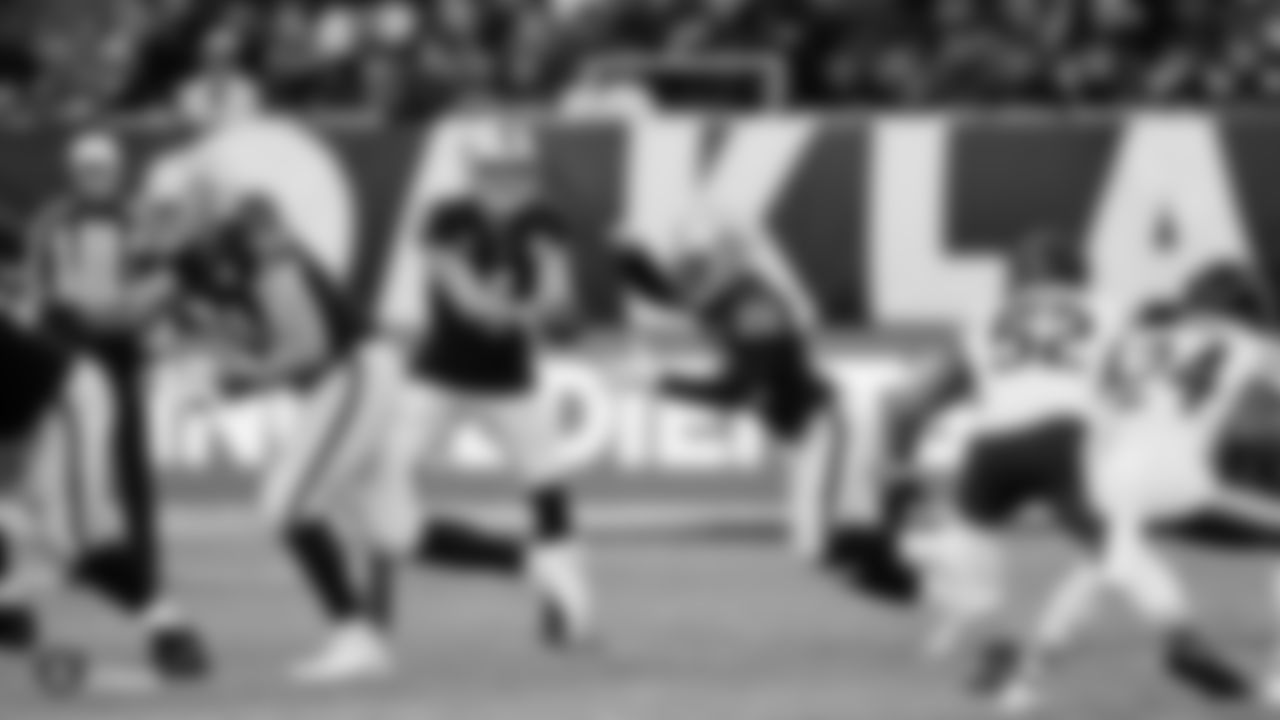Raiders quarterback Derek Carr (4) hands the ball off to running back Josh Jacobs (28) during the game against the Chicago Bears at Tottenham Hotspur Stadium.