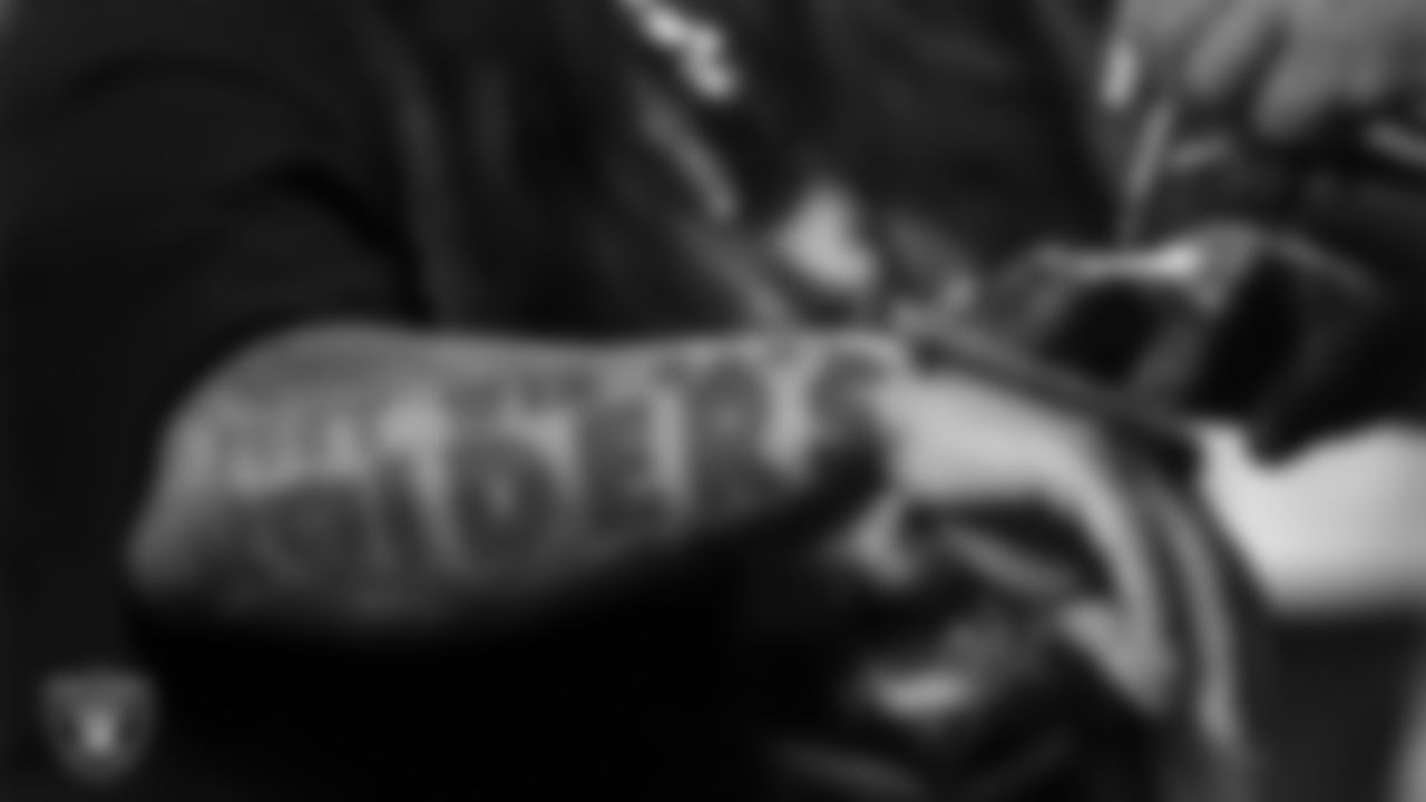 A fan gets an airbrush tattoo during the Season Ticket Member Appreciation Fan Fest at Allegiant Stadium.