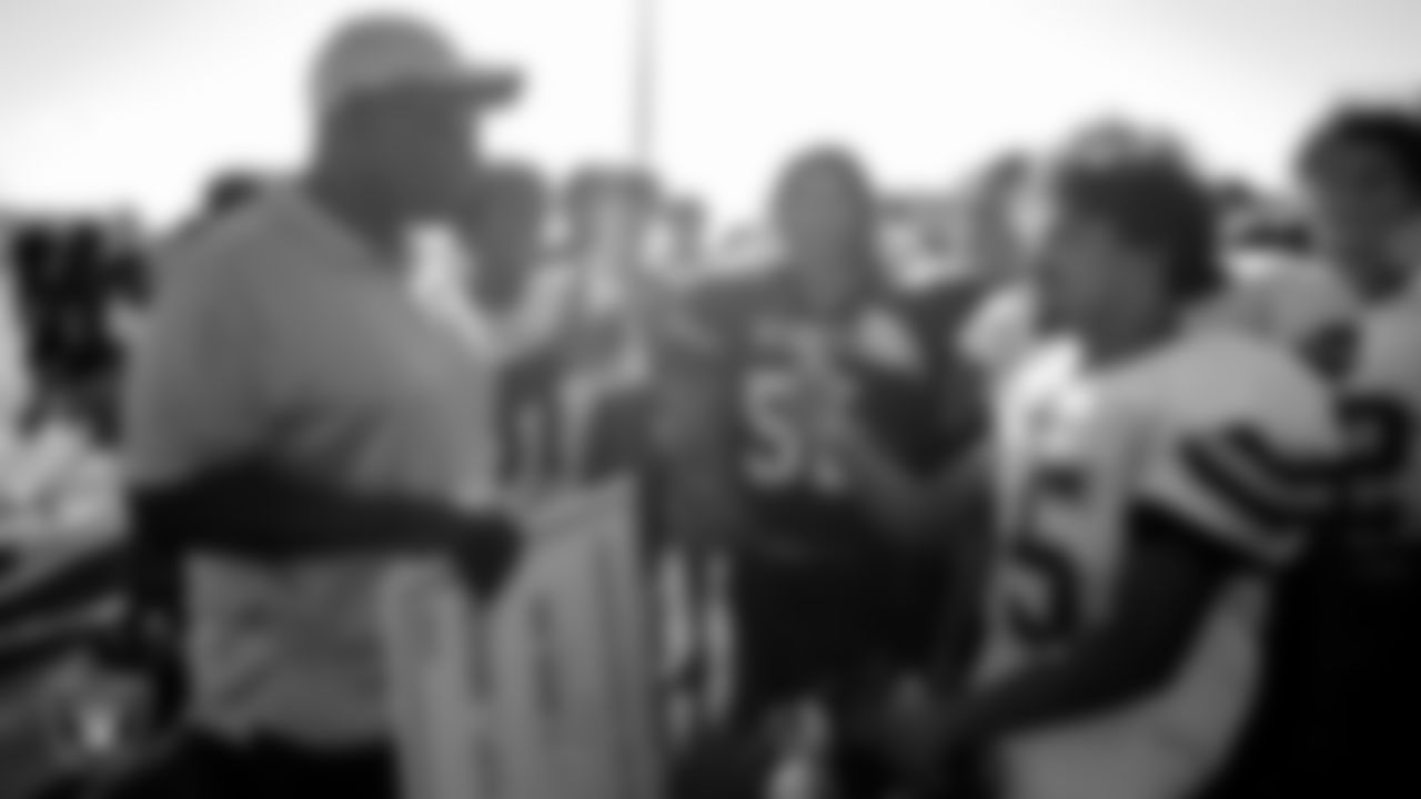 Las Vegas Raiders alumnus Reggie Kinlaw talks to a member of the Las Vegas High School football team after presenting their coach, Erick Capetillo, the Tom Flores High School Coach of the Week award and Jahsire M. as the Most Outstanding Performer.