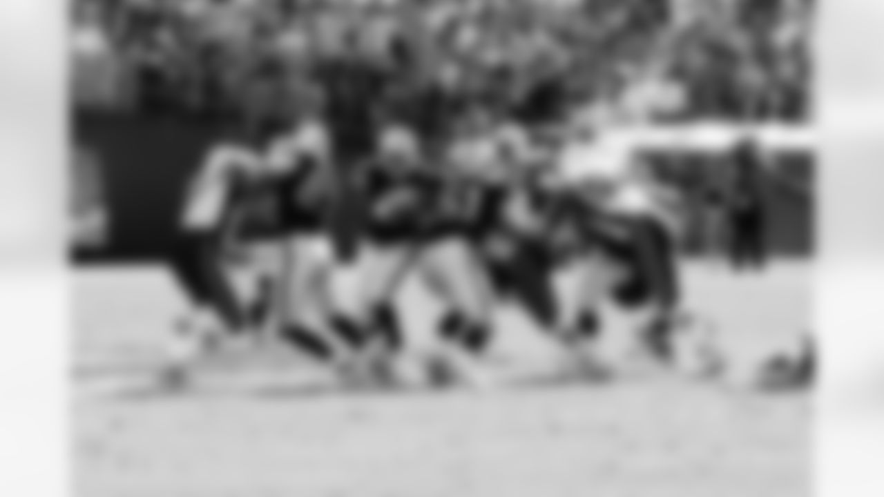RB Michael Bush squeezes through the space created by his offensive line.