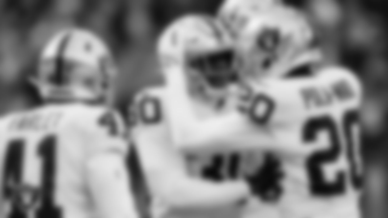 Las Vegas Raiders safety Duron Harmon (30) and safety Isaiah Pola-Mao (20) celebrate on the field during the regular season away game against the Seattle Seahawks at Lumen Field.