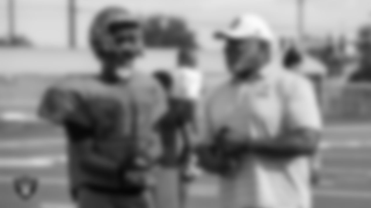 Las Vegas Raiders alumnus Roy Hart talks with a member of the Mojave High School football team.