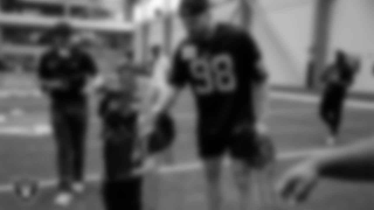 Las Vegas Raiders defensive end Maxx Crosby (98) presents an award to an athlete during the Raiders Play Football Skills Camp at Intermountain Health Performance Center.