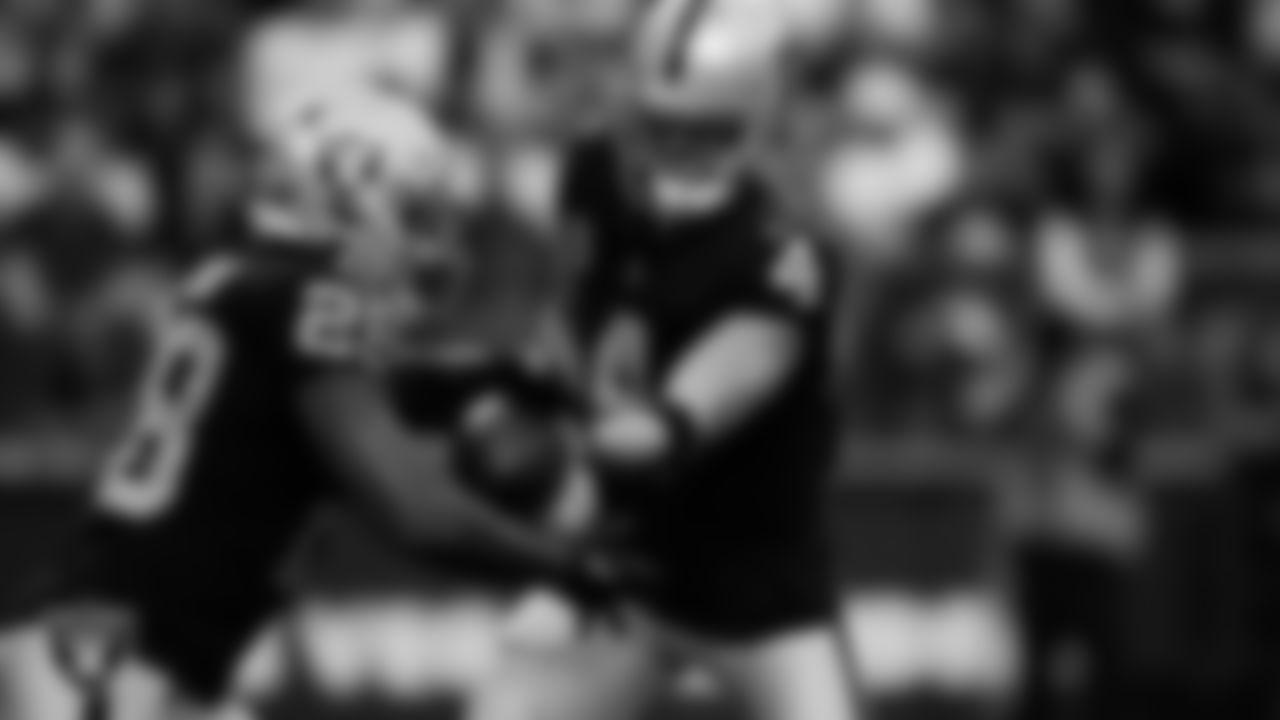Las Vegas Raiders quarterback Derek Carr (4) hands the ball off to running back Josh Jacobs (28) during the regular season home game against the Los Angeles Chargers at Allegiant Stadium.