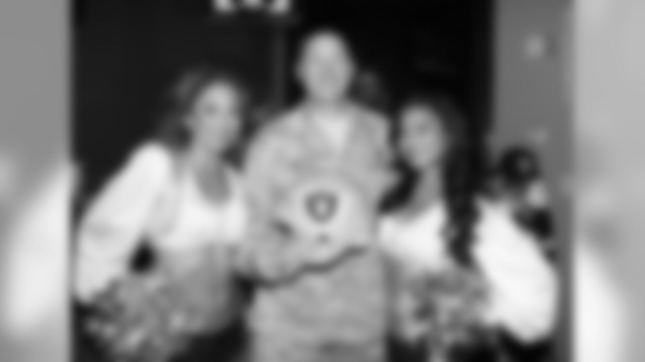 Raiderettes Itza and Althea pose for a photo with a serviceman.
