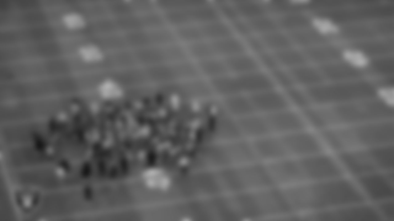 Las Vegas Raiders players and coaches huddle on the field for practice at 2020 Training Camp.