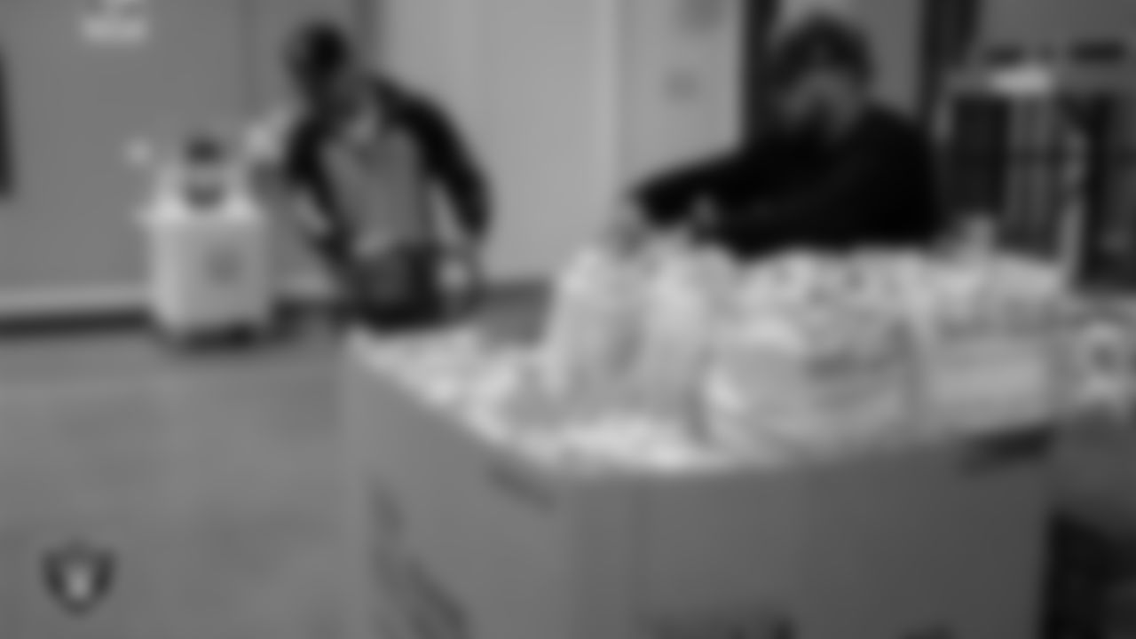 Staff members of the Las Vegas Raiders and ASM pack 600 bags of shelf-stable holiday meals to hand out for Thanksgiving at Three Square Food Bank.