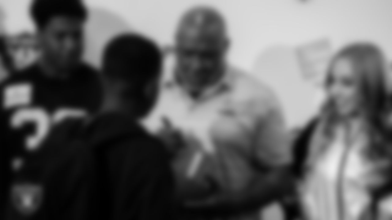 Las Vegas Raiders alumnus Roy Hart signs an autograph during Smith's Holiday Huddle.