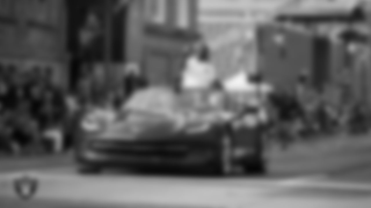 Hall of Famer Charles Woodson rides in the back of a convertible during the Canton Repository Grand Parade.