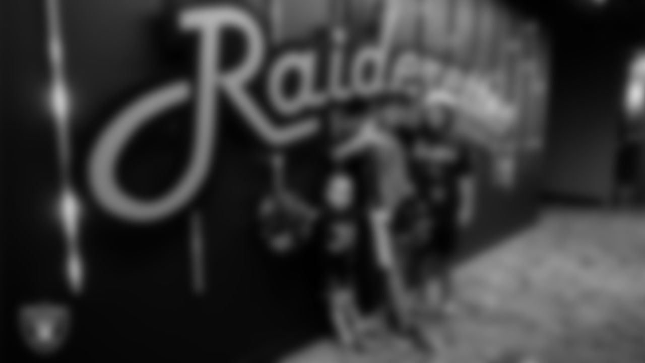 Fans pose for a photo outside the Raiderettes locker room during the Season Ticket Member Appreciation Fan Fest at Allegiant Stadium.