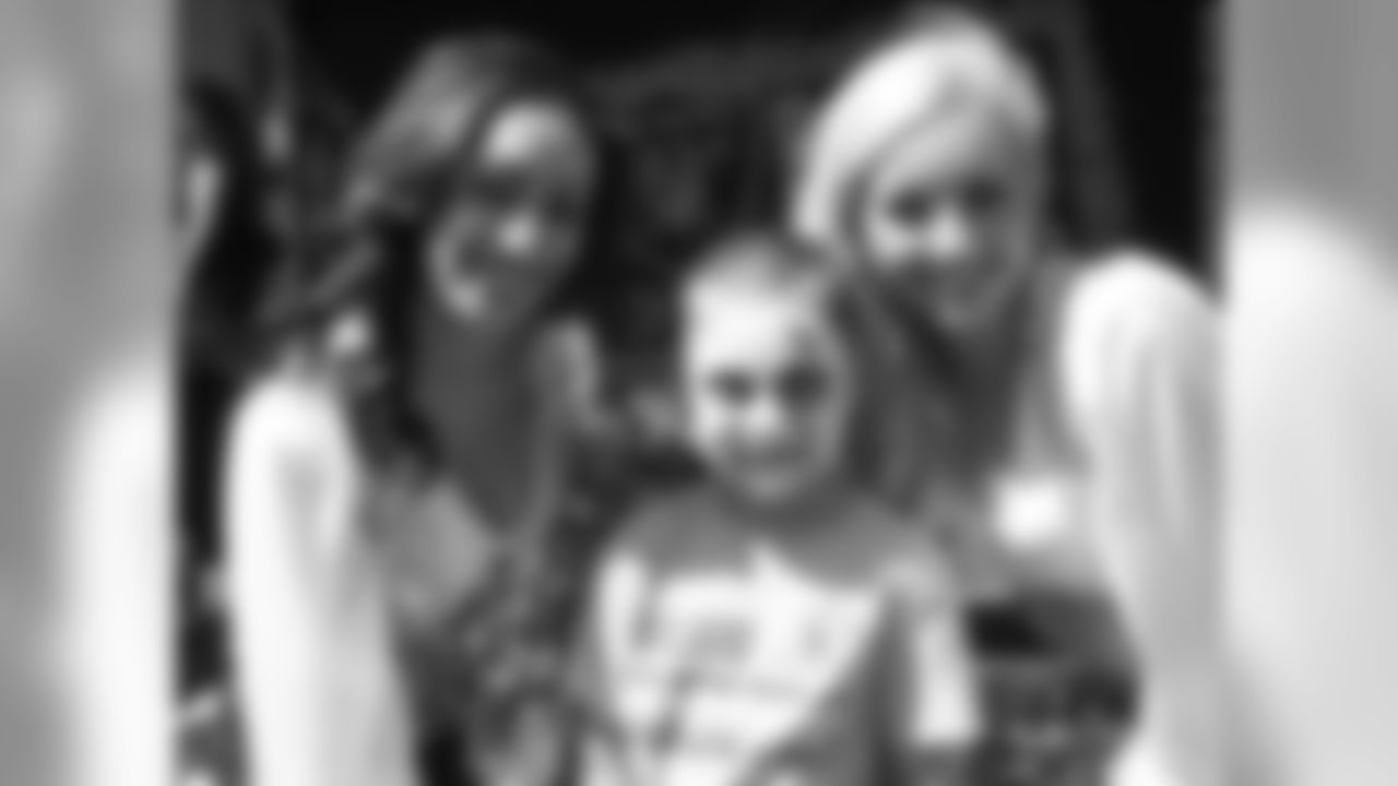Raiderettes Cassie and Maureen pose for a photo with a fan.