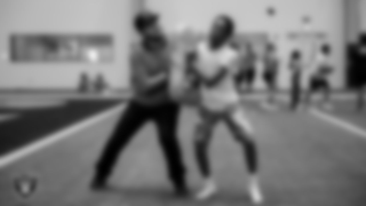 A Fanatics volunteer works with a youth community member as they participate in a drill during Global Impact Day at Intermountain Health Performance Center.