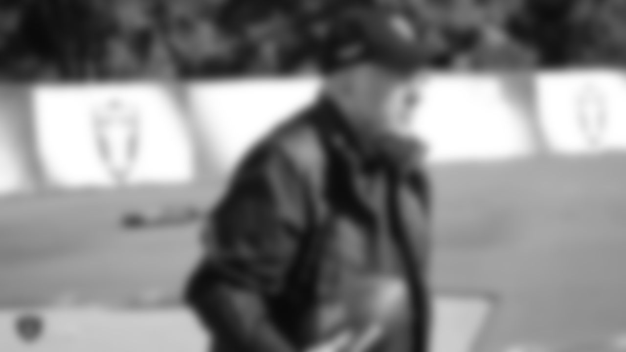 Raiders play-by-play announcer Brent Musburger stands on the field during practice.