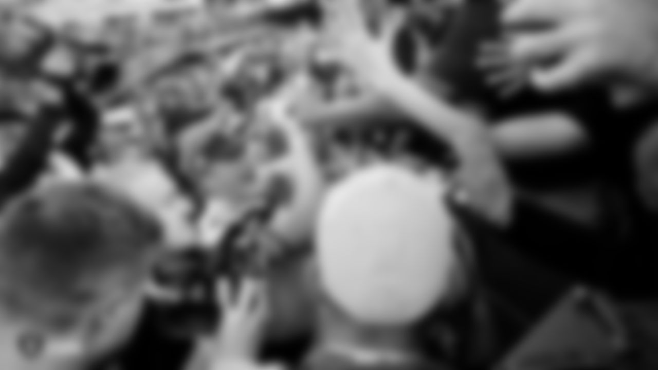 Raiders Head Coach Jon Gruden celebrates with fans following the regular season game against the Cincinnati Bengals at the Oakland-Alameda County Coliseum.