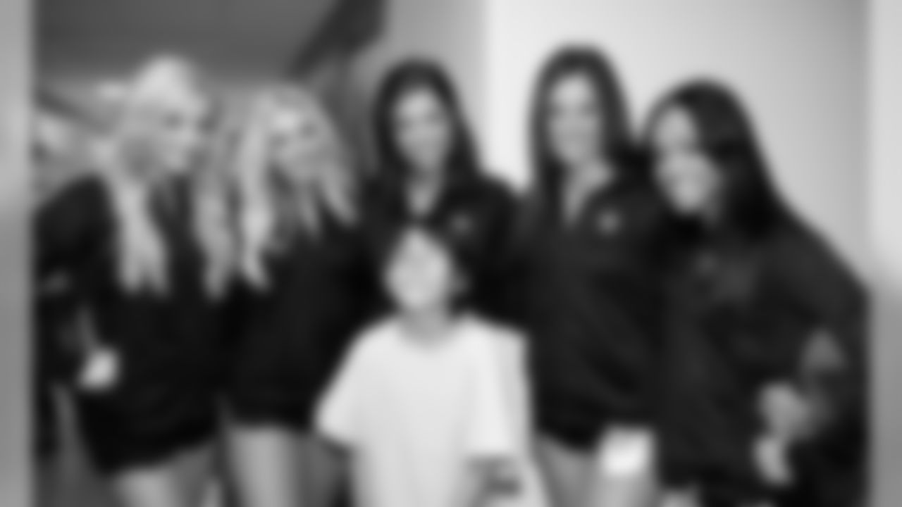 Raiderettes Maureen, Tiphanie, Mallorie, Diana and Tori pose for a photo with a happy patient. Photo by Tony Gonzales.