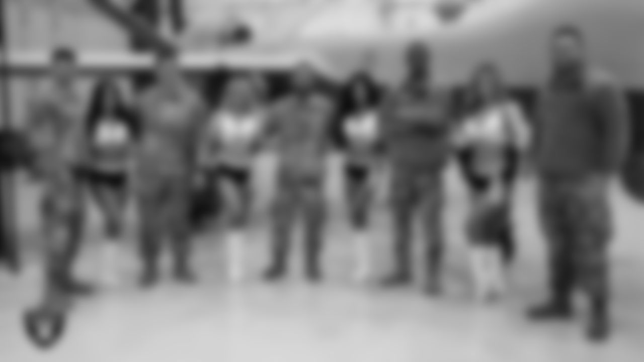 Raiderettes Audrey, Jennifer, Monica D. and Taylor pose for a photo with Air Force members from Creech Air Force Base.