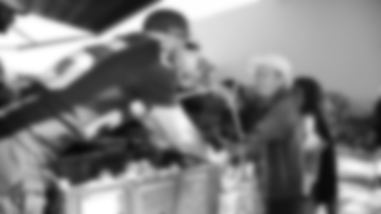 Oakland Raiders players work with the Alameda County Community Food Bank Mobile Pantry to sort and distribute food to low-income families at Ashland Village Apartments, Tuesday, September 18, 2018, in San Leandro, California.