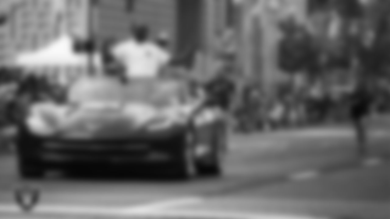 Hall of Famer Charles Woodson rides in the back of a convertible during the Canton Repository Grand Parade.