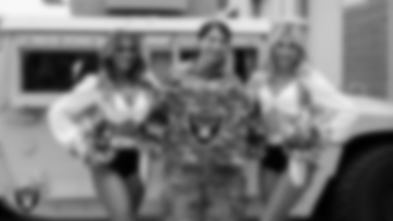 Raiderettes Bree and Madison pose for a photo with a service member of Nellis Air Force Base during Operation Donut Drop.
