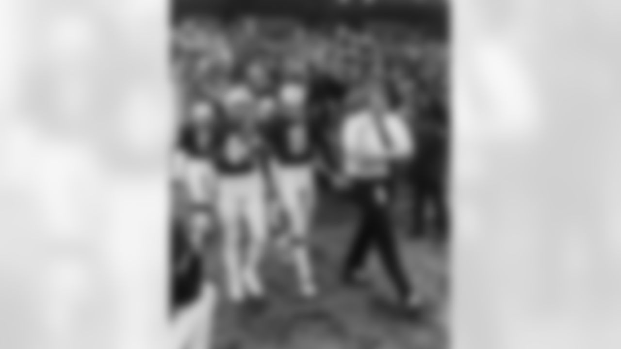 Coach John Madden walks out to the field with George Atkinson and Ray Guy.
