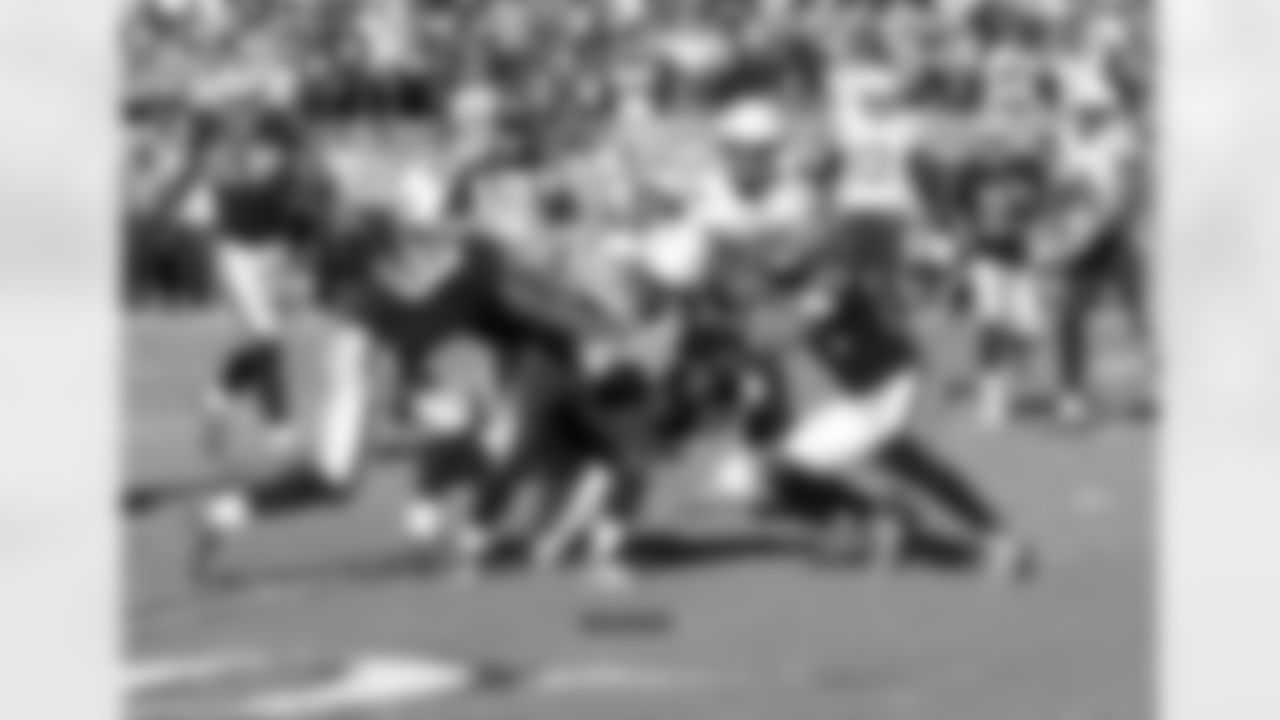 The defenders team up to tackle RB Branden Oliver.