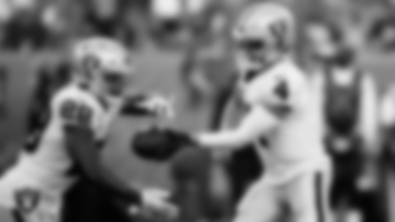 Las Vegas Raiders quarterback Derek Carr (4) hands the ball off to running back Josh Jacobs (28) during the regular season away game against the Denver Broncos.
