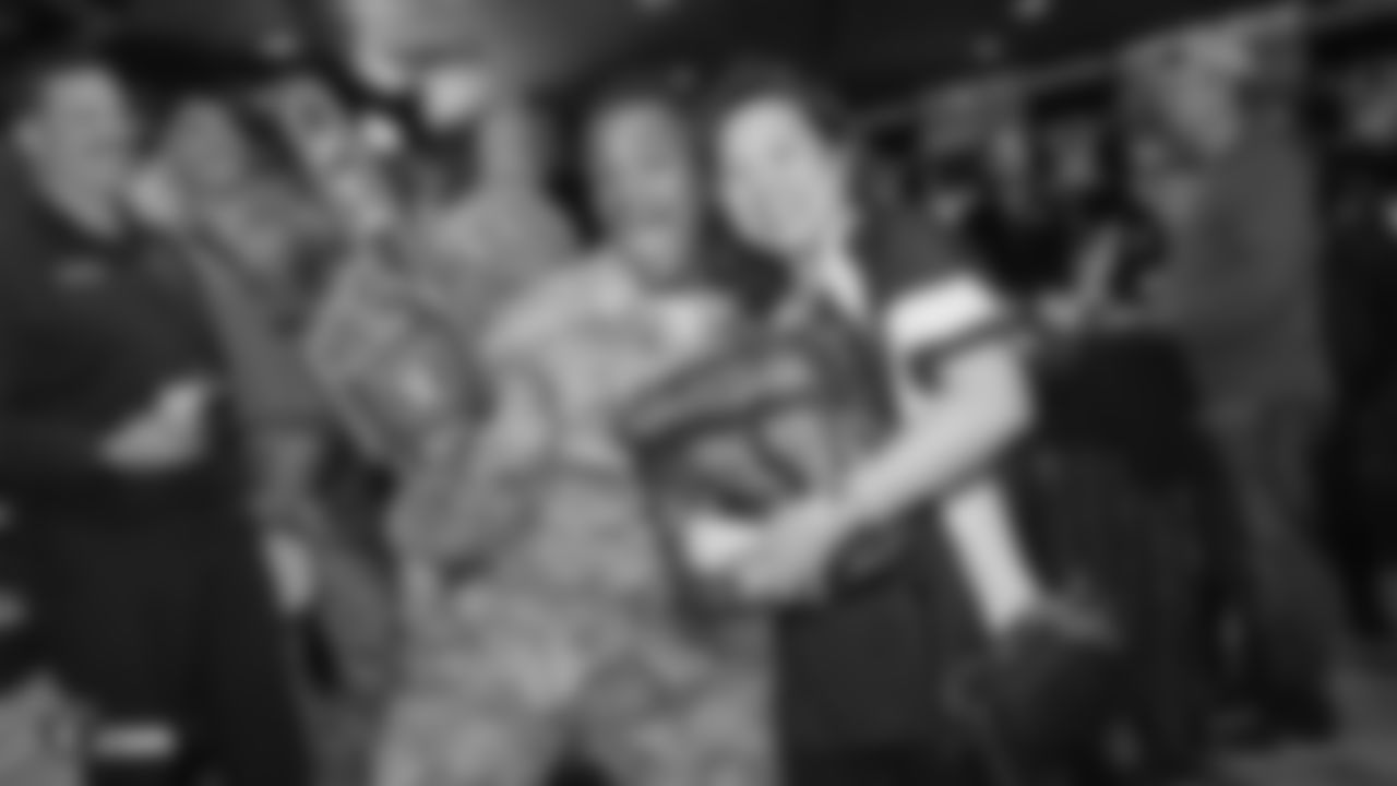 An attendee poses for a photo with a serviceman at Nellis Air Force Base after winning a raffle prize at a Watch Party for members of the Las Vegas Raiders Family Association, troops from Nellis Air Force Base and their families during the Raiders regular season game against the New York Jets.