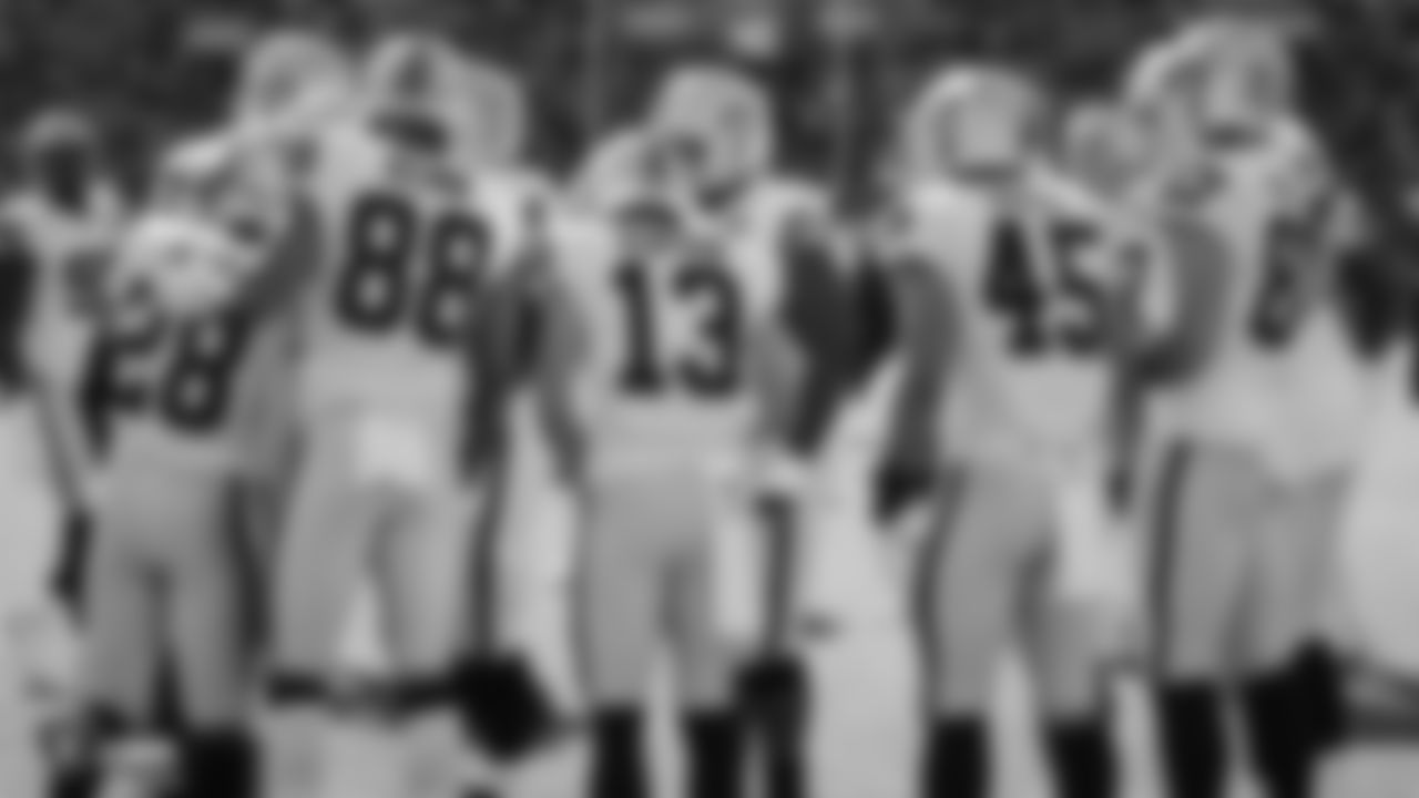 The Raiders huddle during warms up before the regular season game against the Green Bay Packers at Lambeau Field.