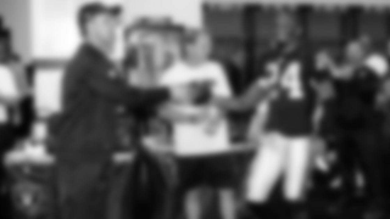 Raiders Head Coach Dennis Allen gives cornerback Charles Woodson (24) the game ball in the locker room after the regular season home game against the San Diego Chargers.
