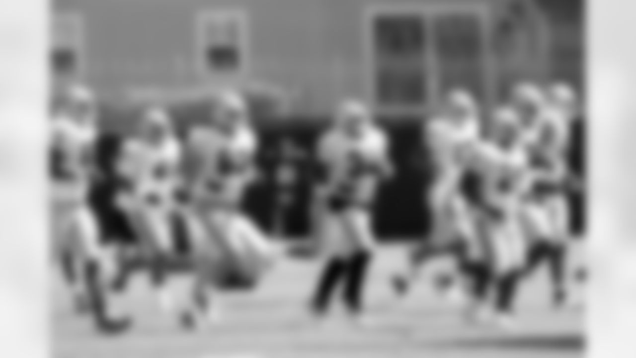 The offensive players run up the field.