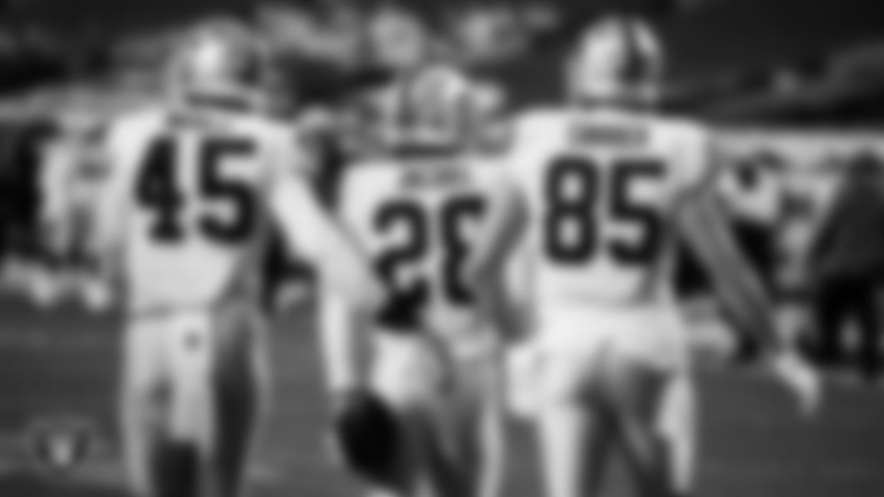 Las Vegas Raiders running back Josh Jacobs (28) is congratulated by fullback Alec Ingold (45) and tight end Derek Carrier (85) after rushing for a 1-yard touchdown during the regular season away game against the Denver Broncos.