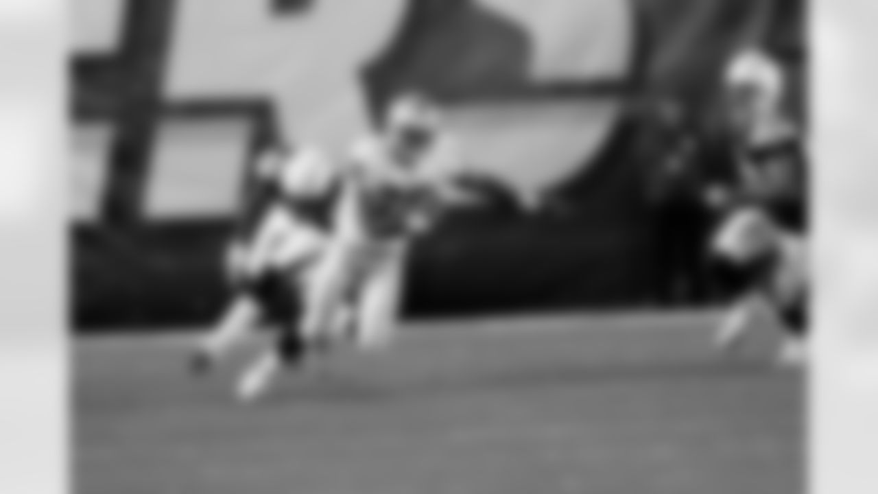 RB Taiwan Jones cuts back towards the middle to avoid the defenders.
