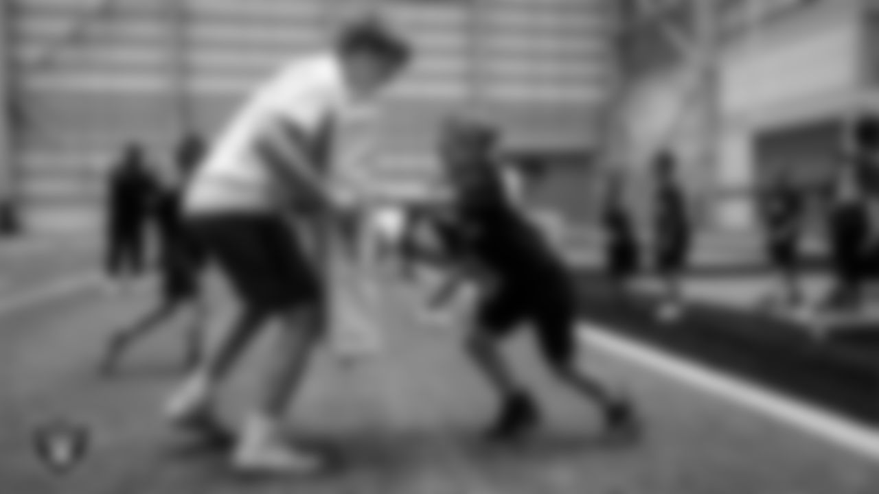 A Green Valley High School football player works with an athlete on a drill during the Raiders Play Football Skills Camp at Intermountain Health Performance Center.