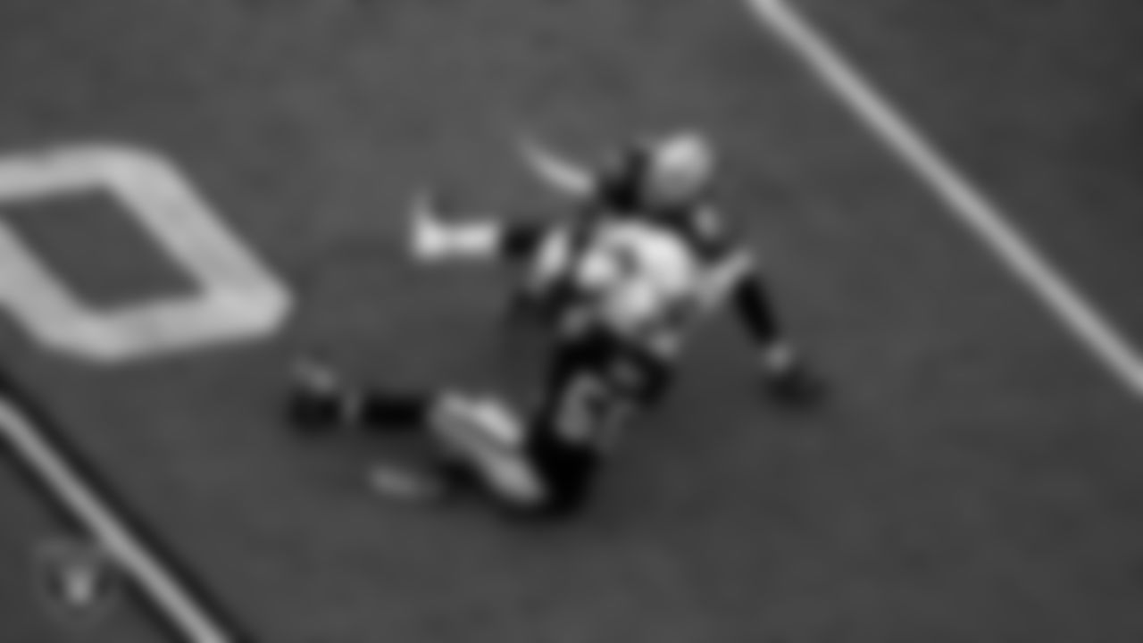 Las Vegas Raiders defensive end Chandler Jones (55) and cornerback Amik Robertson (21) make a tackle during the regular season home game against the Denver Broncos at Allegiant Stadium.