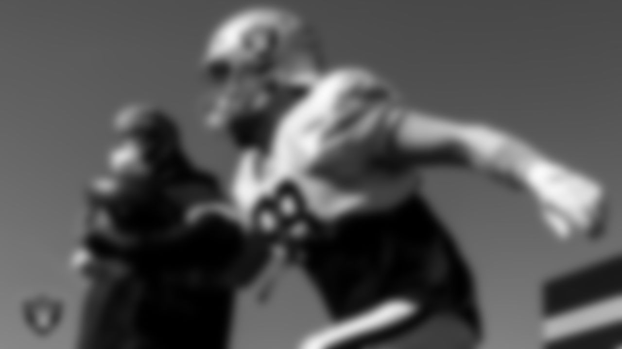 Las Vegas Raiders assistant defensive backs coach Taver Johnson and defensive end Maxx Crosby (98) during practice.
