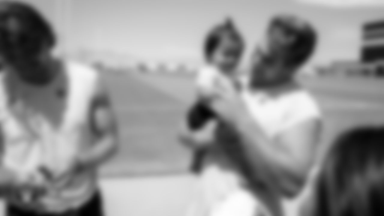 Las Vegas Raiders tight end Michael Mayer (87) holds a fan's baby after practice at 2023 Training Camp at Intermountain Health Performance Center.