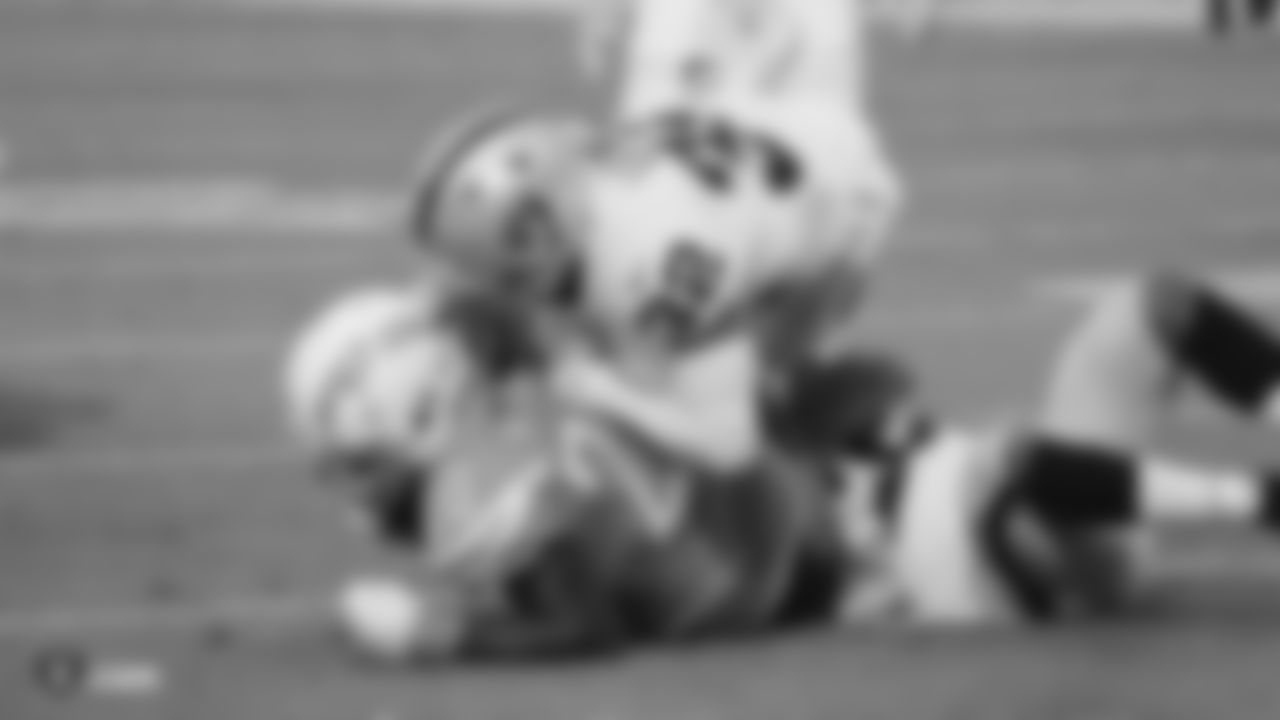 Raiders safety Dallin Leavitt (32) and cornerback Keisean Nixon (22) make a tackle during the regular season game against the Los Angeles Chargers.