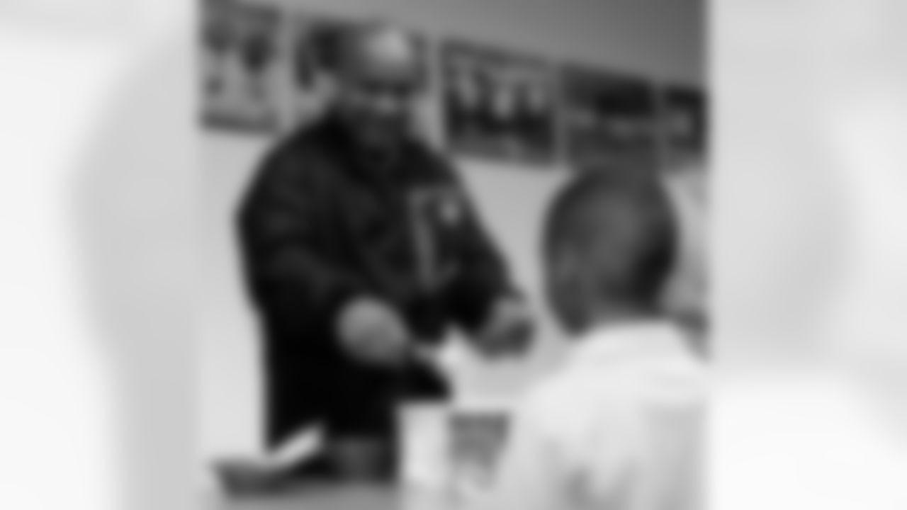 Head Coach Hue Jackson scoops up the ice cream for the kids. Photo by Tony Gonzales.