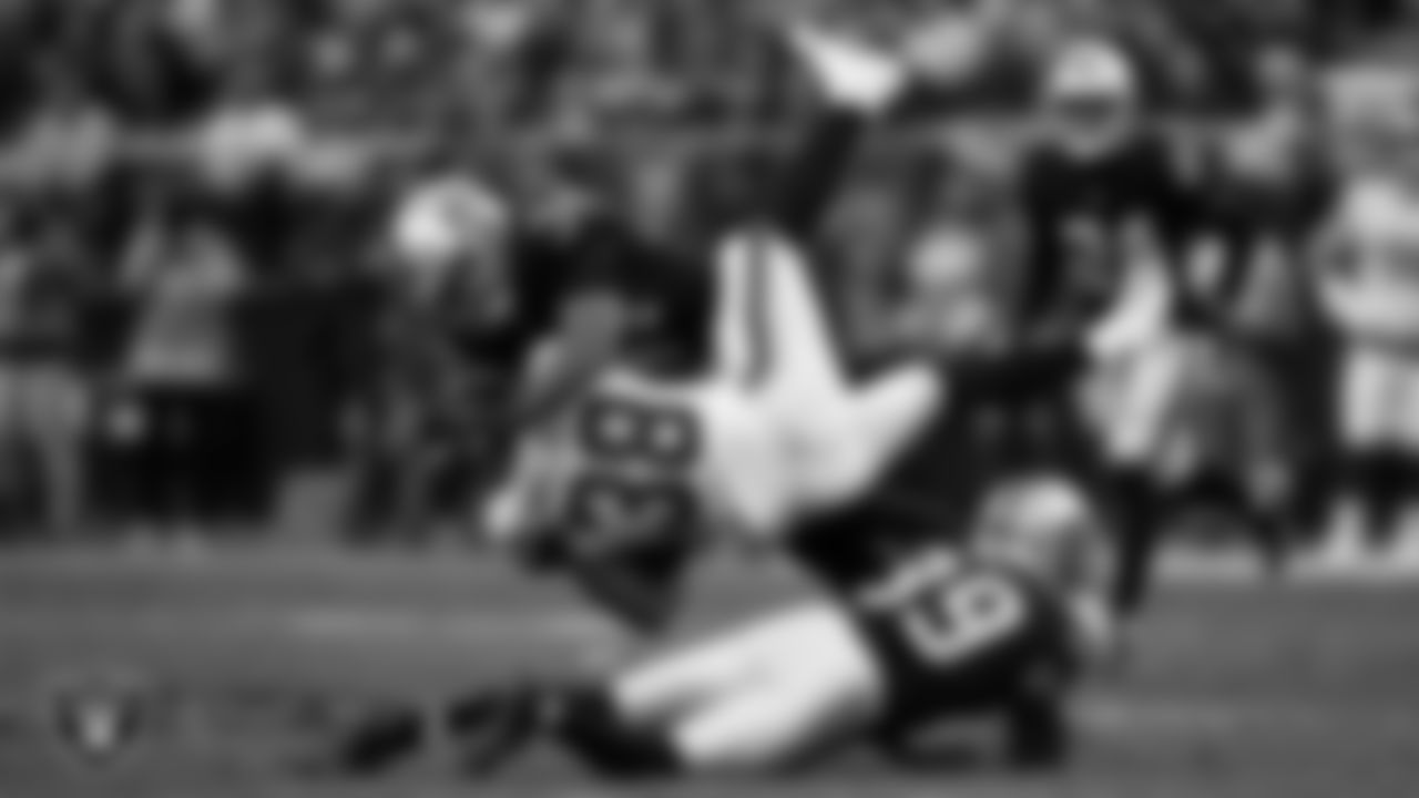 Las Vegas Raiders linebacker K.J. Wright (34) and cornerback Nate Hobbs (39) make a tackle during the regular season home game against the Washington Football Team.