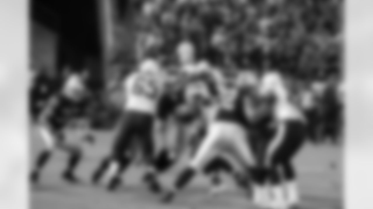 The Raiders defense wraps up the ball carrier.