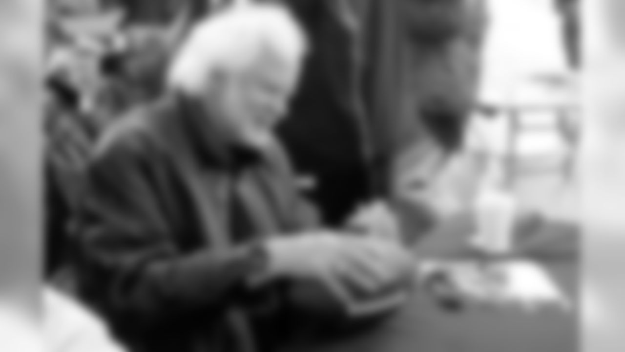 Raiders Legend Kenny Stabler signs a football for a fan. Photo by Tony Gonzales.