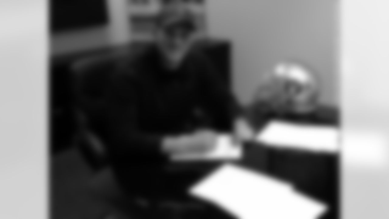 P Daniel Zychlinski signs his contract.