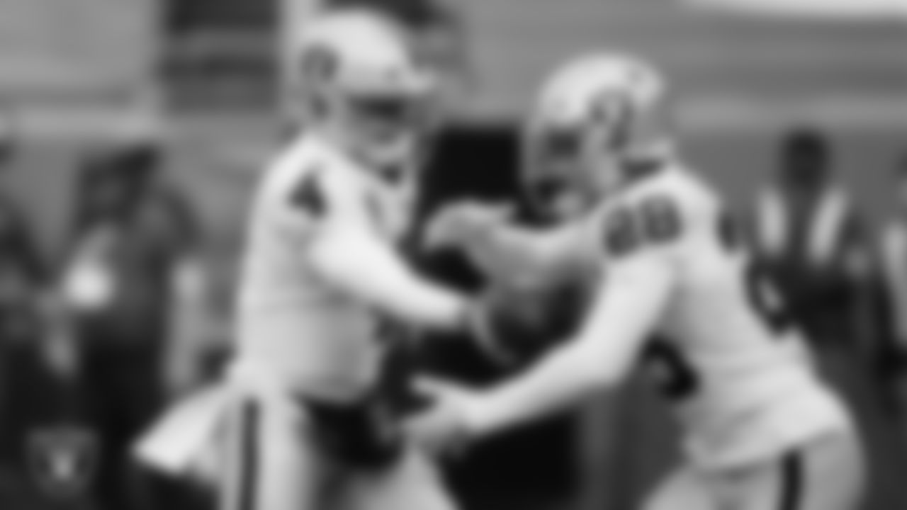 Las Vegas Raiders quarterback Derek Carr (4) hands the ball off to running back Josh Jacobs (28) during the regular season away game against the Denver Broncos.
