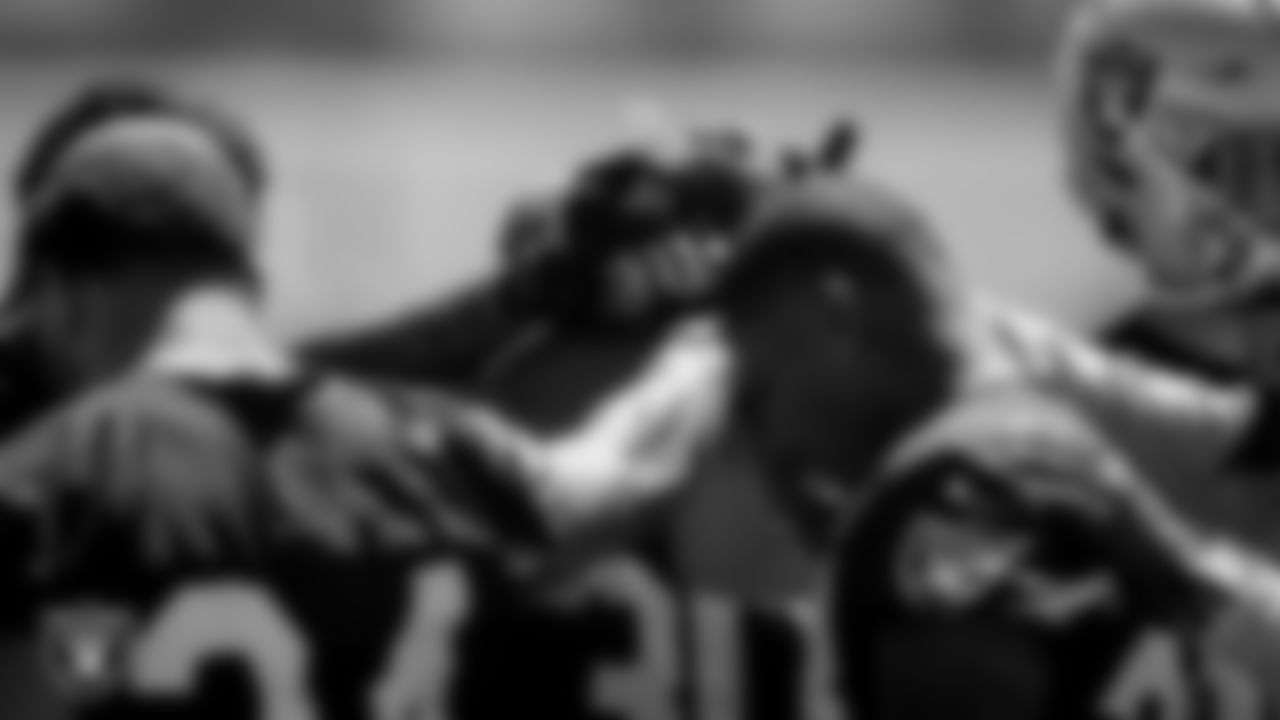 Las Vegas Raiders running backs huddle during practice.