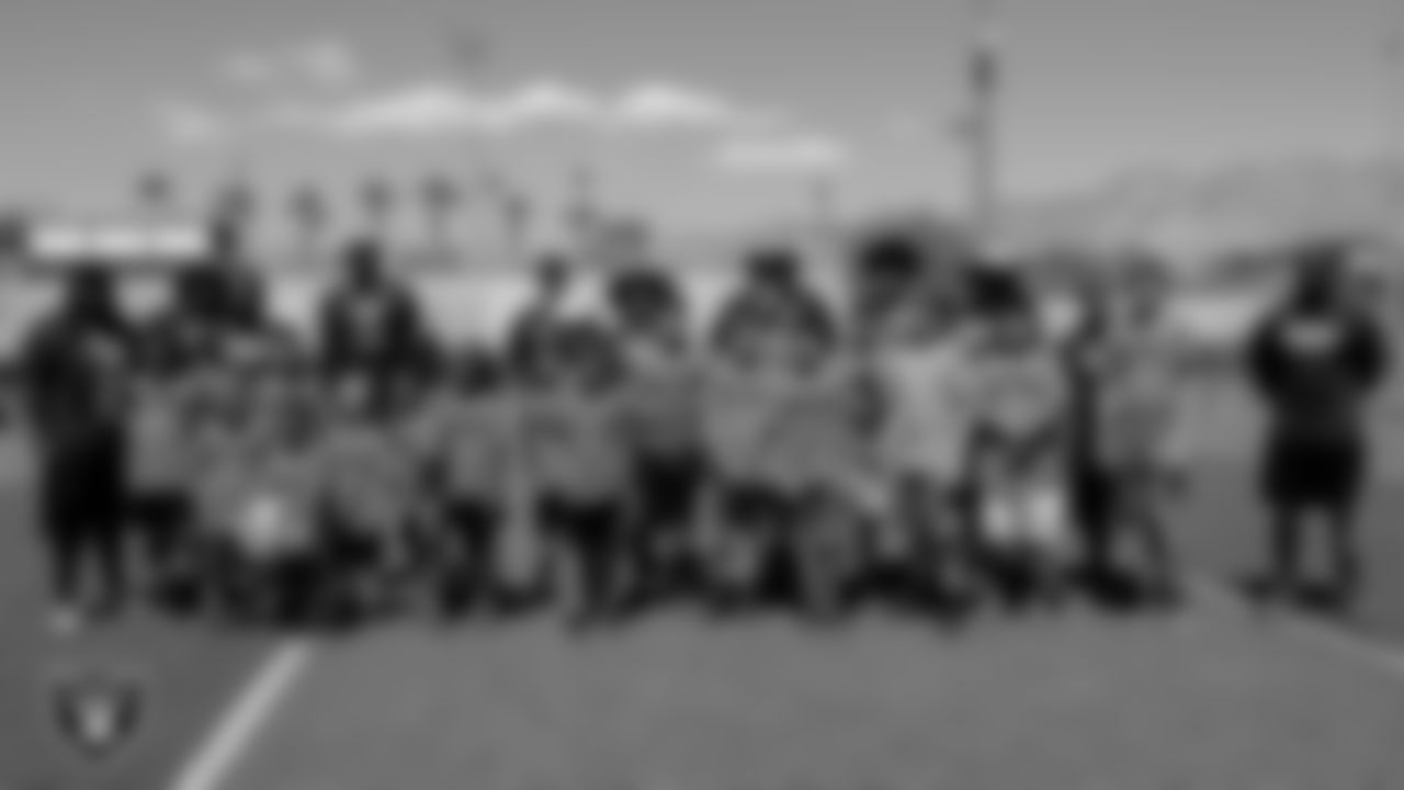 Youth football players and coaches pose for a photo after going through drills during the USA Football Summer Blitz.