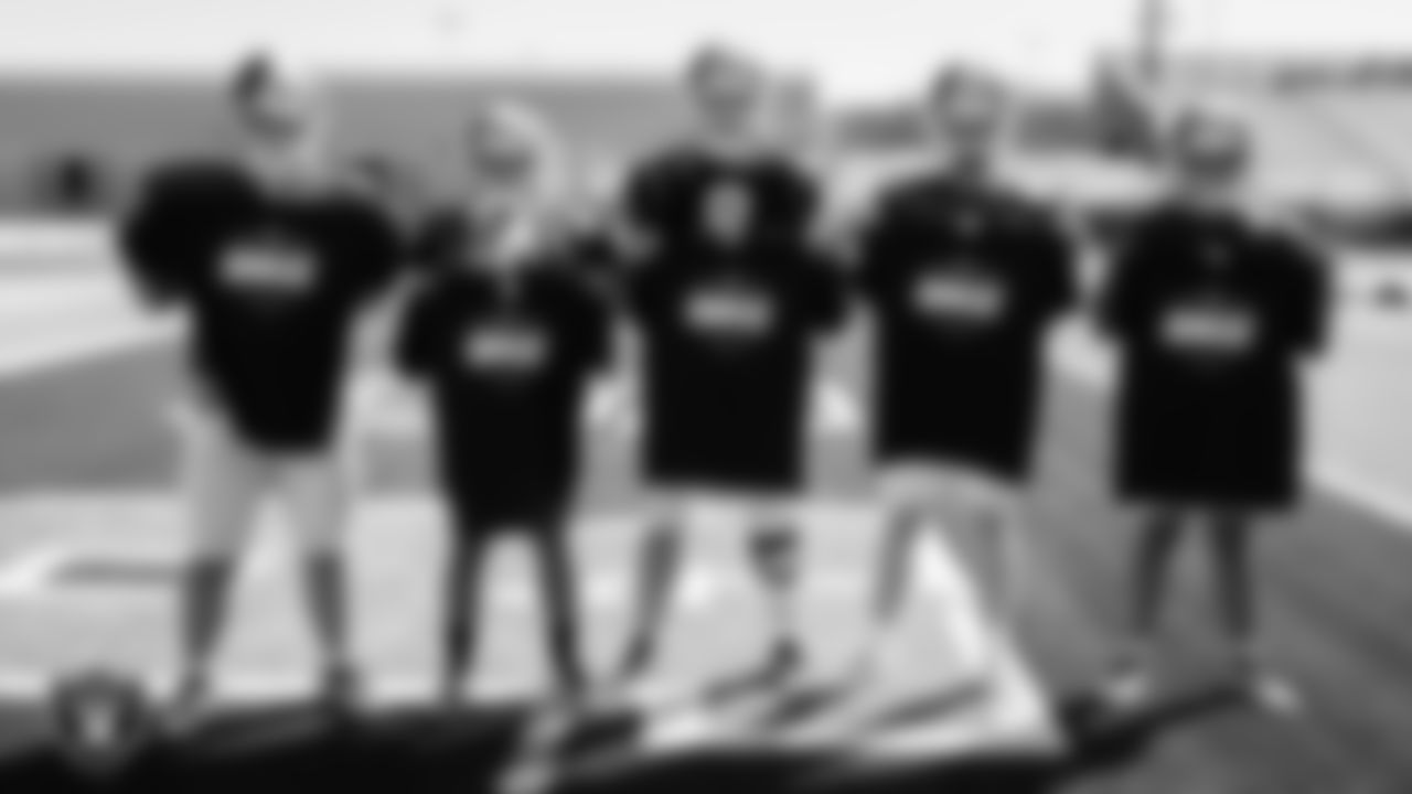Members of the Green Valley High School football team show off their High School Football Showcase shirts during practice at Green Valley High School.