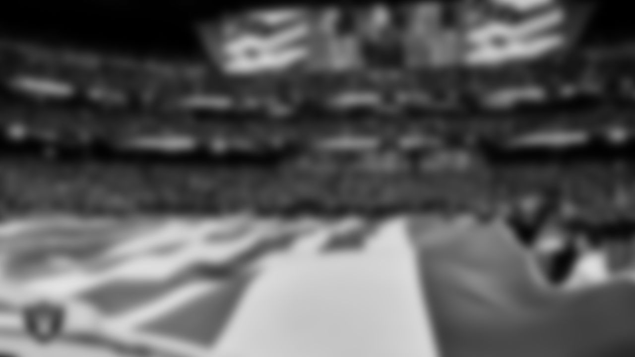 The American flag is displayed by Personal Seat License (PSL) holders on the field during the national anthem before the Las Vegas Raiders' regular season home game against the Denver Broncos at Allegiant Stadium.