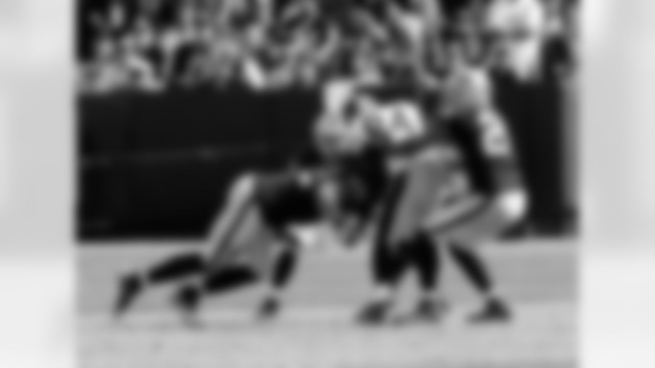 LB Philip Wheeler and DB Michael Huff tackle WR Antonio Brown.