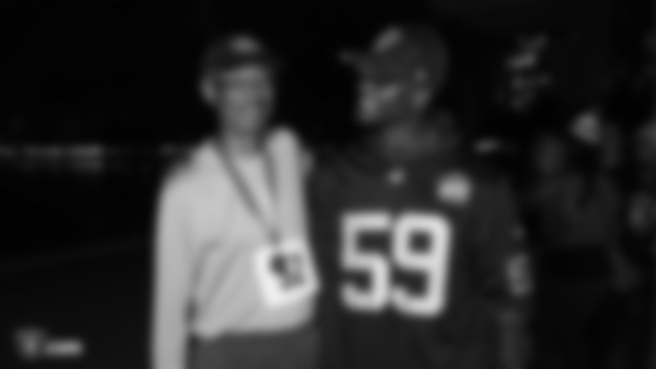Raiders linebacker Tahir Whitehead (59) congratulates a race participant at the finish line at a Run Life's Course 5K run/walk and famous Grooves Dance Workout.