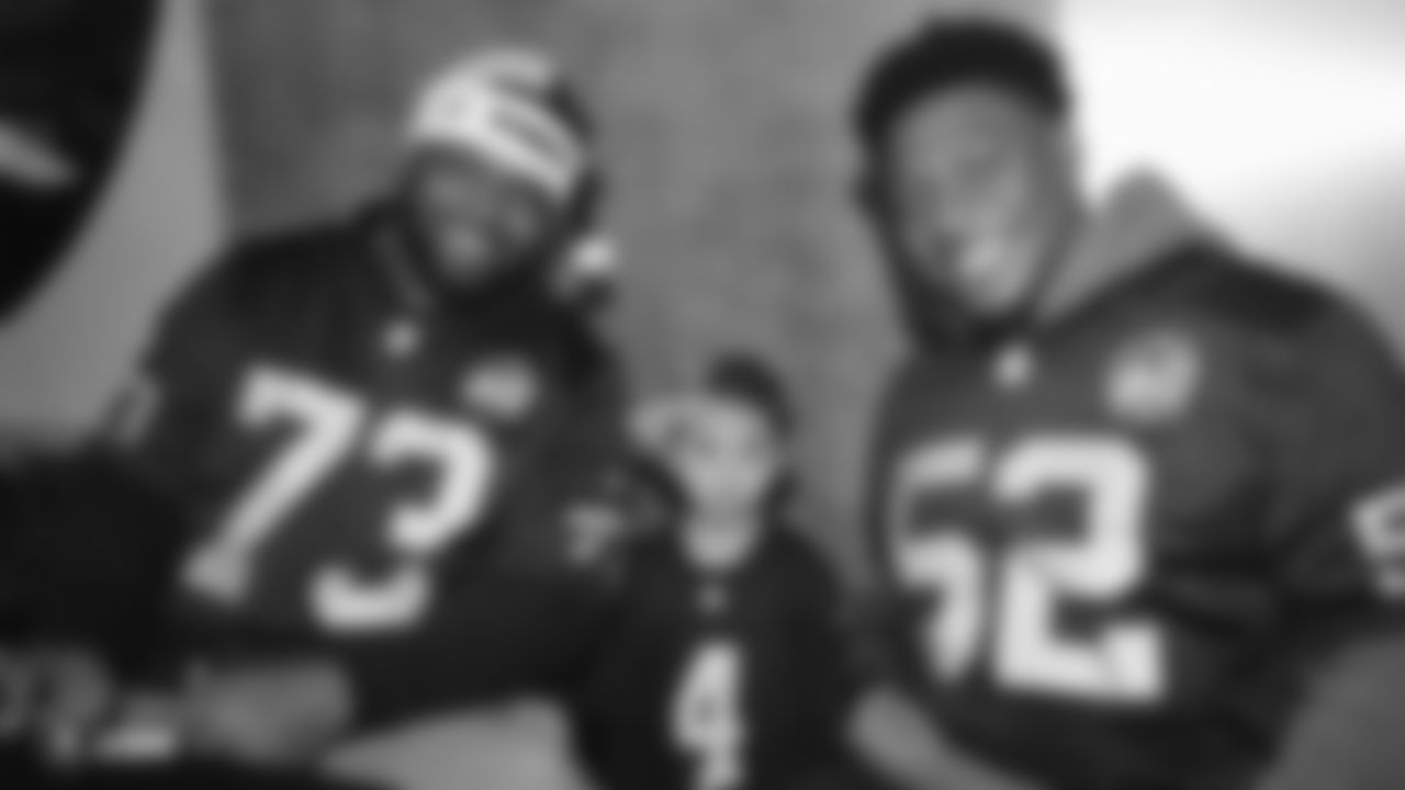 Raiders defensive tackle Maurice Hurst (73) and linebacker Marquel Lee (52) pose for a photo with a young fan during the Raiders Foundation's Toys for Tots drive.